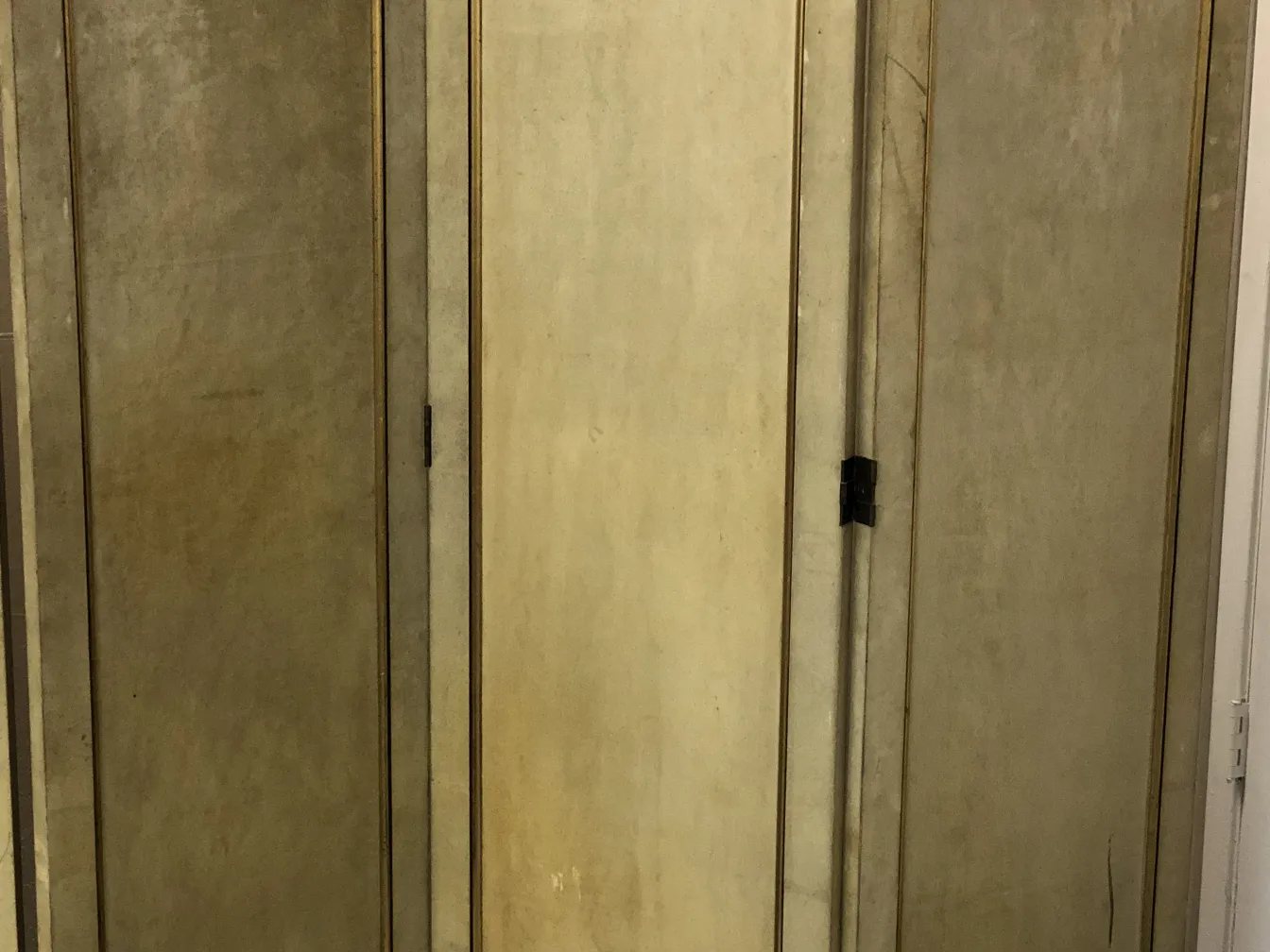 two antique folding screens with hardware, light colors in an elegant setting