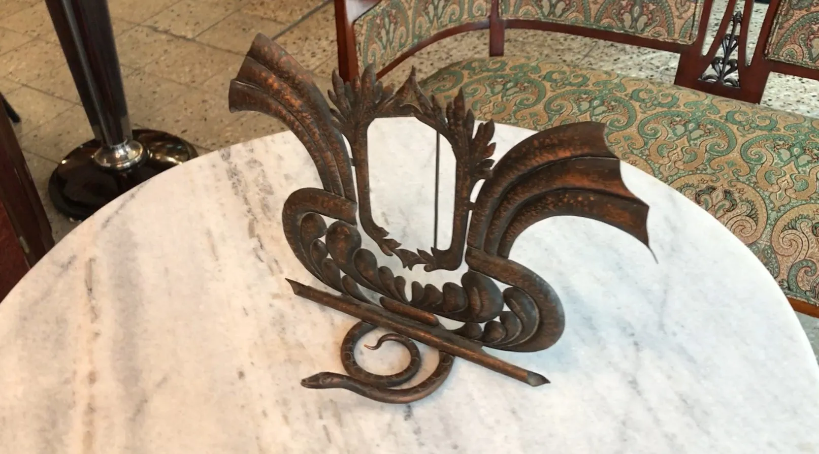 Portarretrato antiguo con diseño decorativo y detalles elaborados sobre una superficie clara.