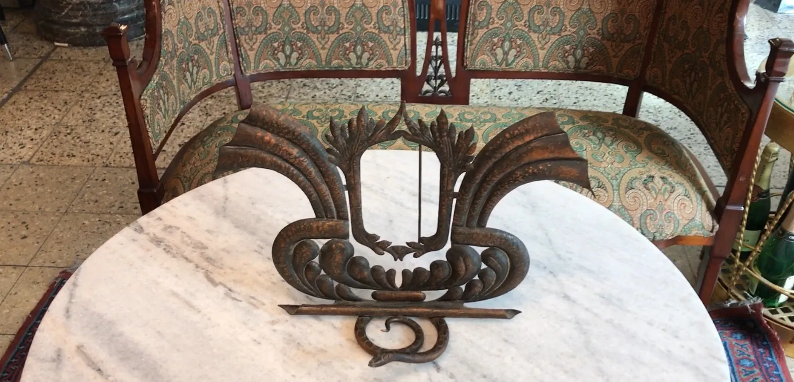 Cadre photo ancien avec un design élaboré et des détails ornementaux, placé sur une table en marbre dans un cadre élégant.