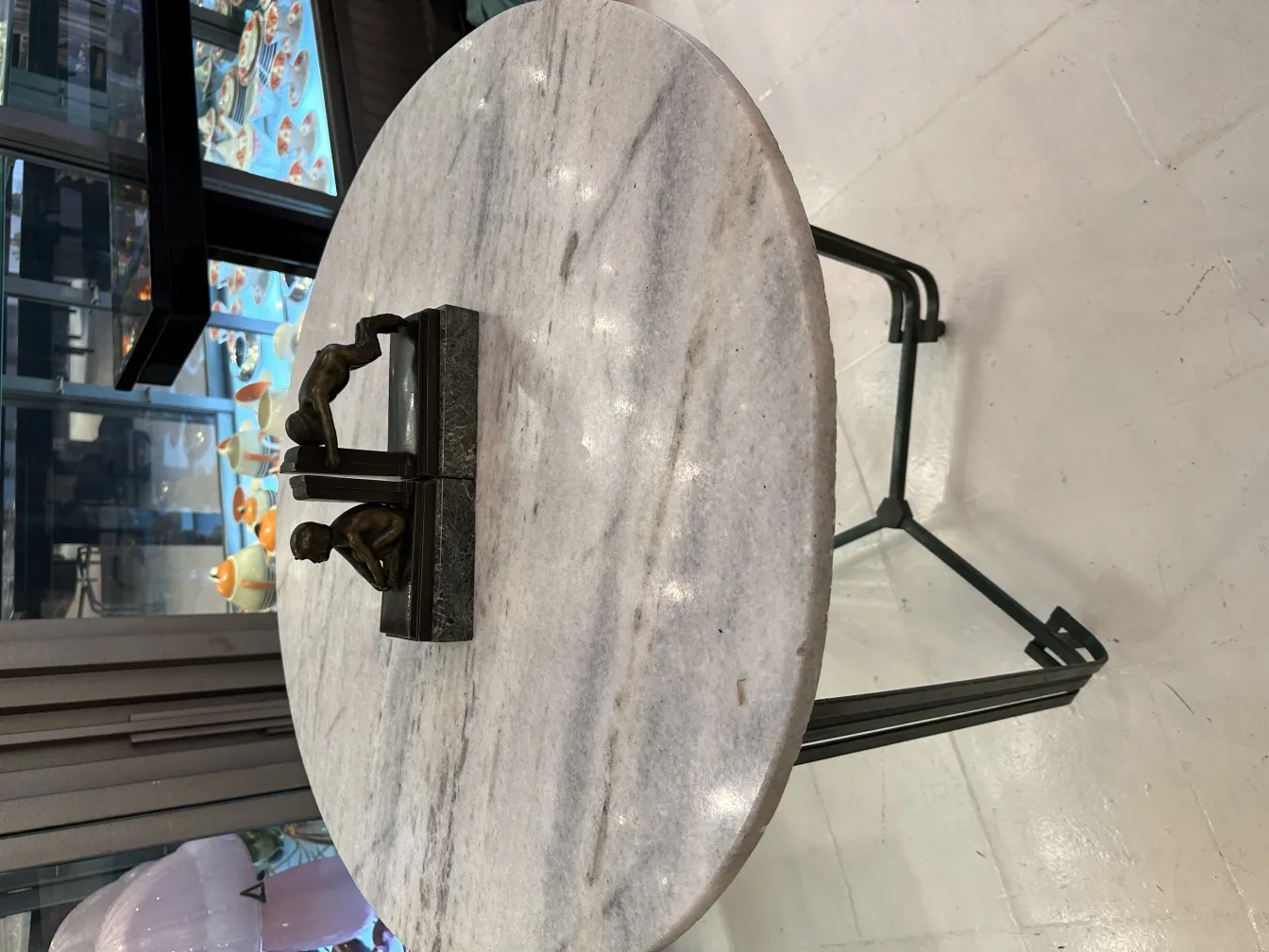 Suportes antigos para livros em uma mesa de mármore, com figuras.