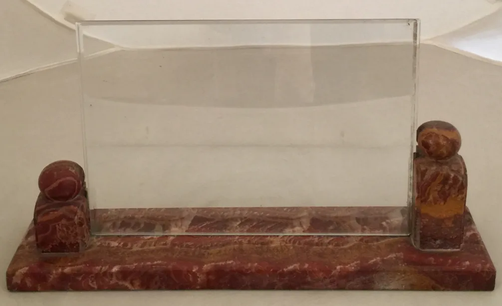 Antiker Bilderrahmen mit dekorativem Ständer, heller Hintergrund.