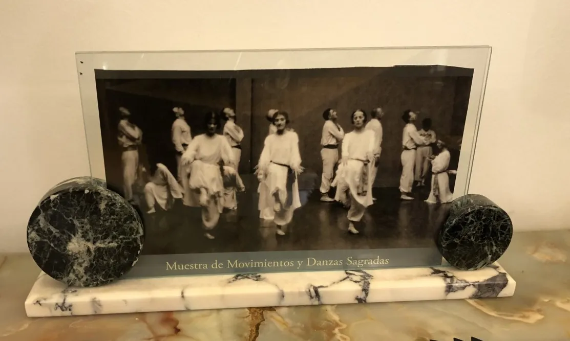 Antique picture frame showcasing a black and white photo of dance, with circular decorations.
