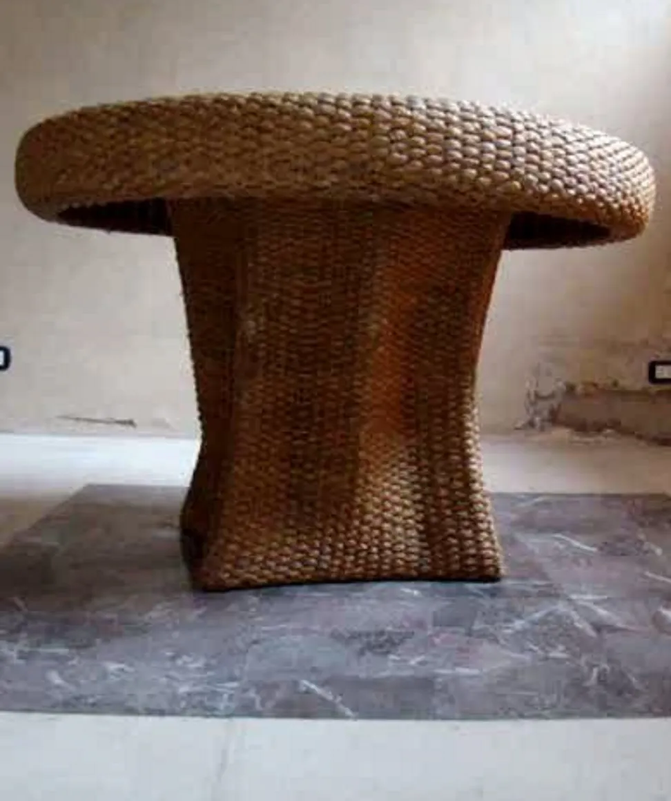 antique dining table with distinctive design and curved edge, set against a minimalist background