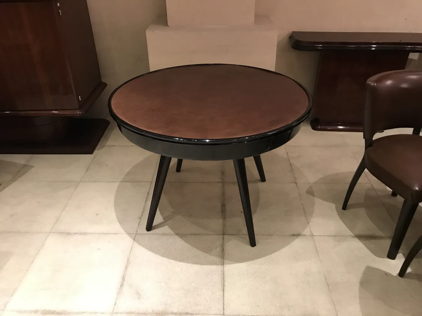 mesa de comedor antigua con superficie redonda y patas negras, entorno acogedor