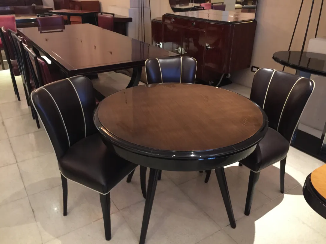 Runder antiker Esstisch mit vier Stühlen, elegantes Ambiente.