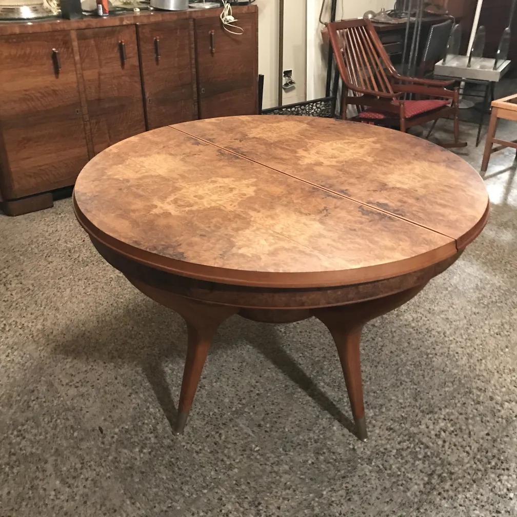 Round antique dining table for four people in a retro setting with chairs.