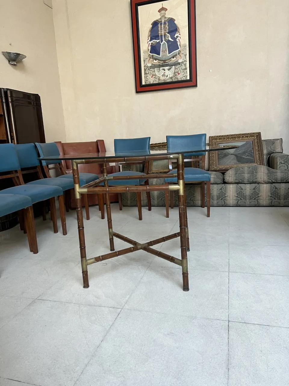 Table à manger ancienne pour 6 personnes dans un cadre accueillant, décorée avec des chaises bleues et des œuvres d'art sur les murs.