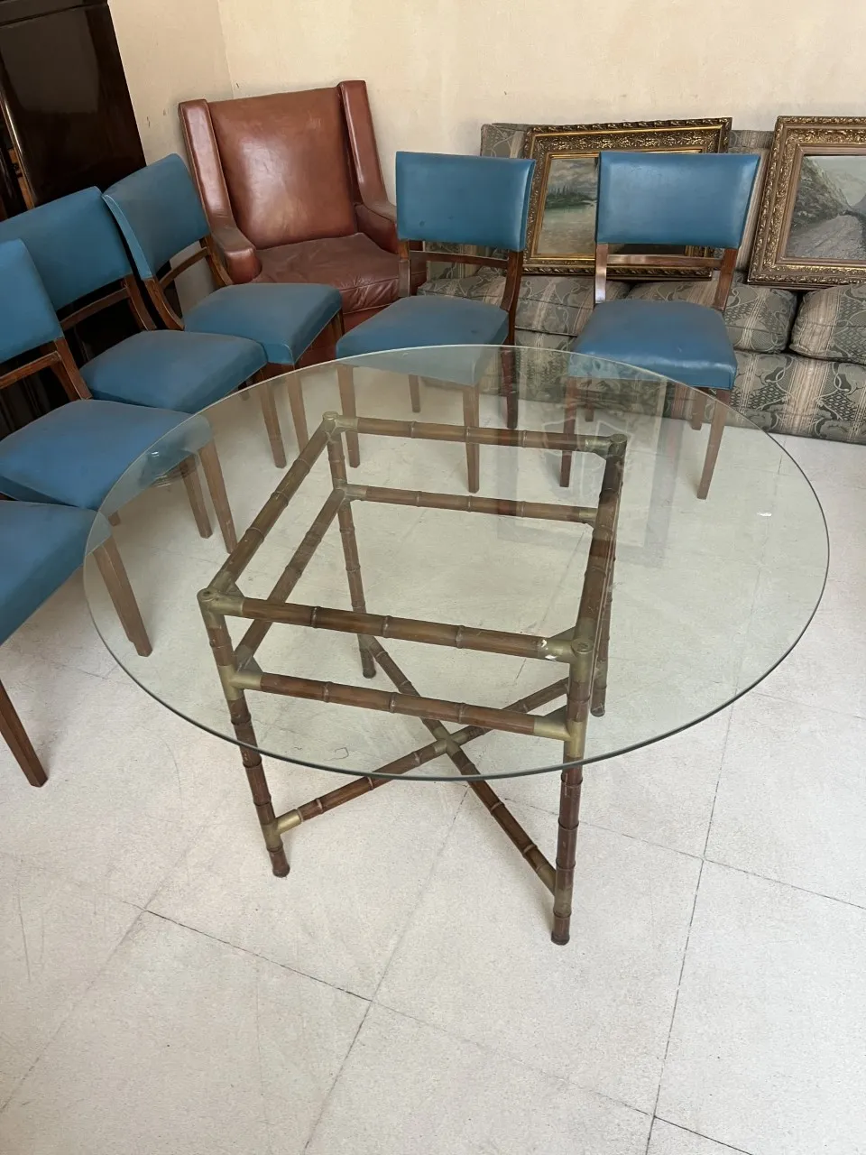 Antique dining table for six people with blue chairs in the background.