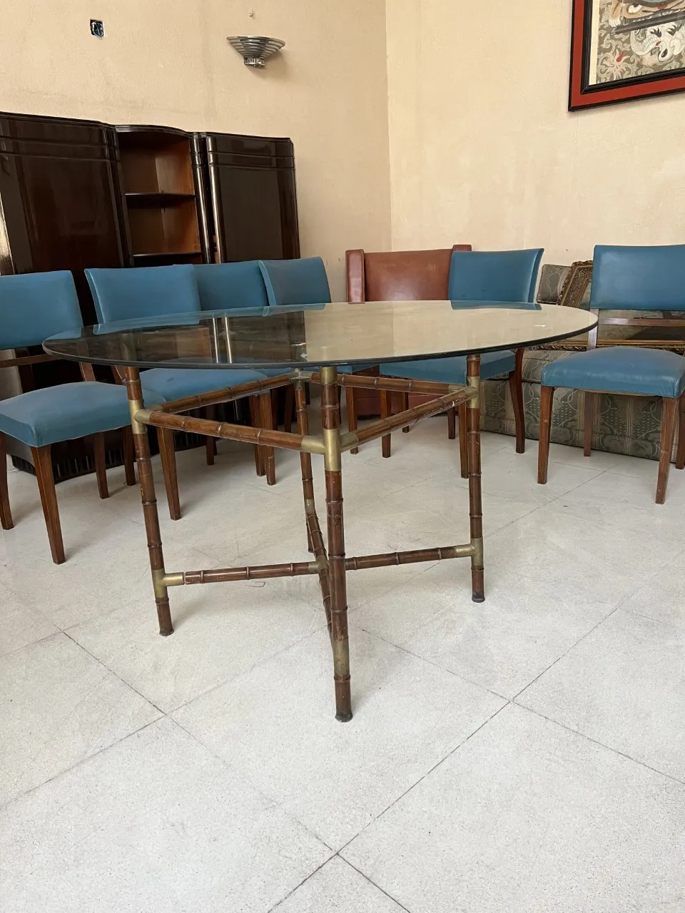 Table à manger ancienne pour six personnes avec des chaises bleues dans un cadre convivial.