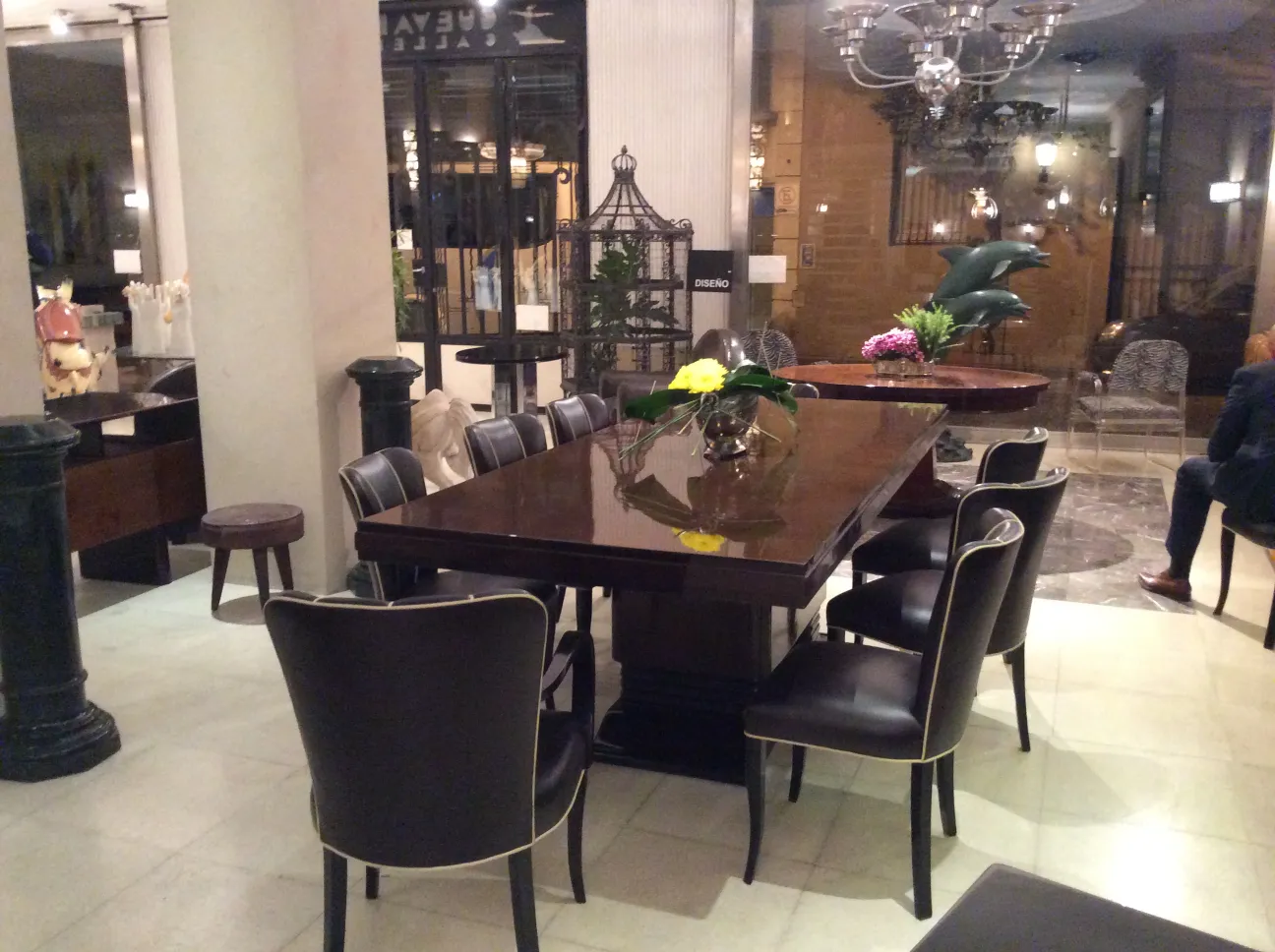 Mesa de comedor antigua para 10 personas, decorada con flores.