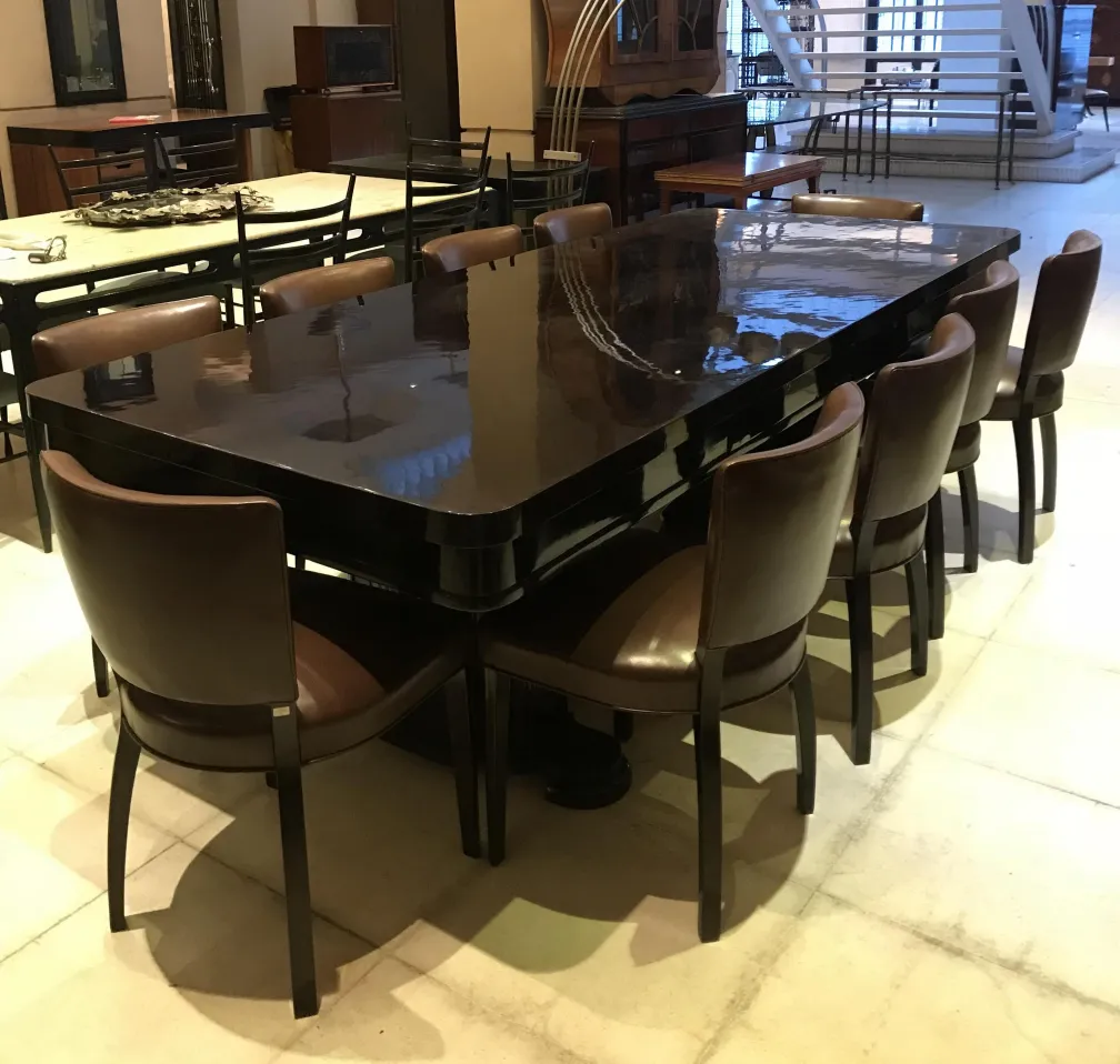 mesa de comedor antigua de gran tamaño con 10 sillas elegantes en un ambiente acogedor
