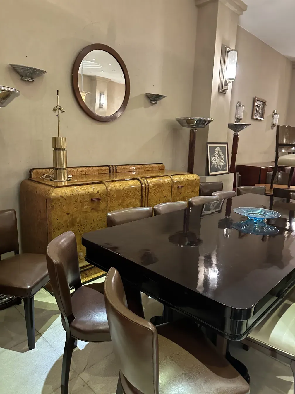 Mesa de jantar antiga com cadeiras elegantes, ambiente acolhedor.