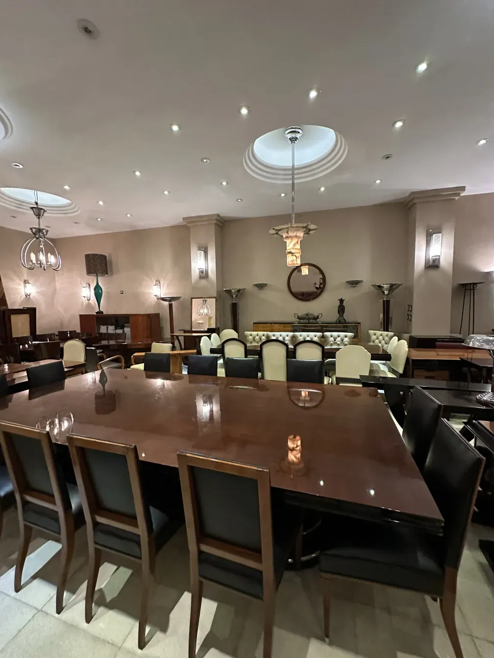 Mesa de jantar antiga para 14 pessoas em um ambiente elegante.