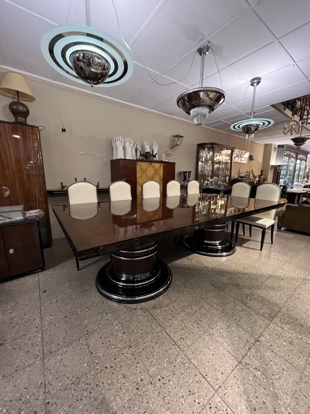 Mesa de comedor antigua para 14 personas en un entorno elegante con decoración.