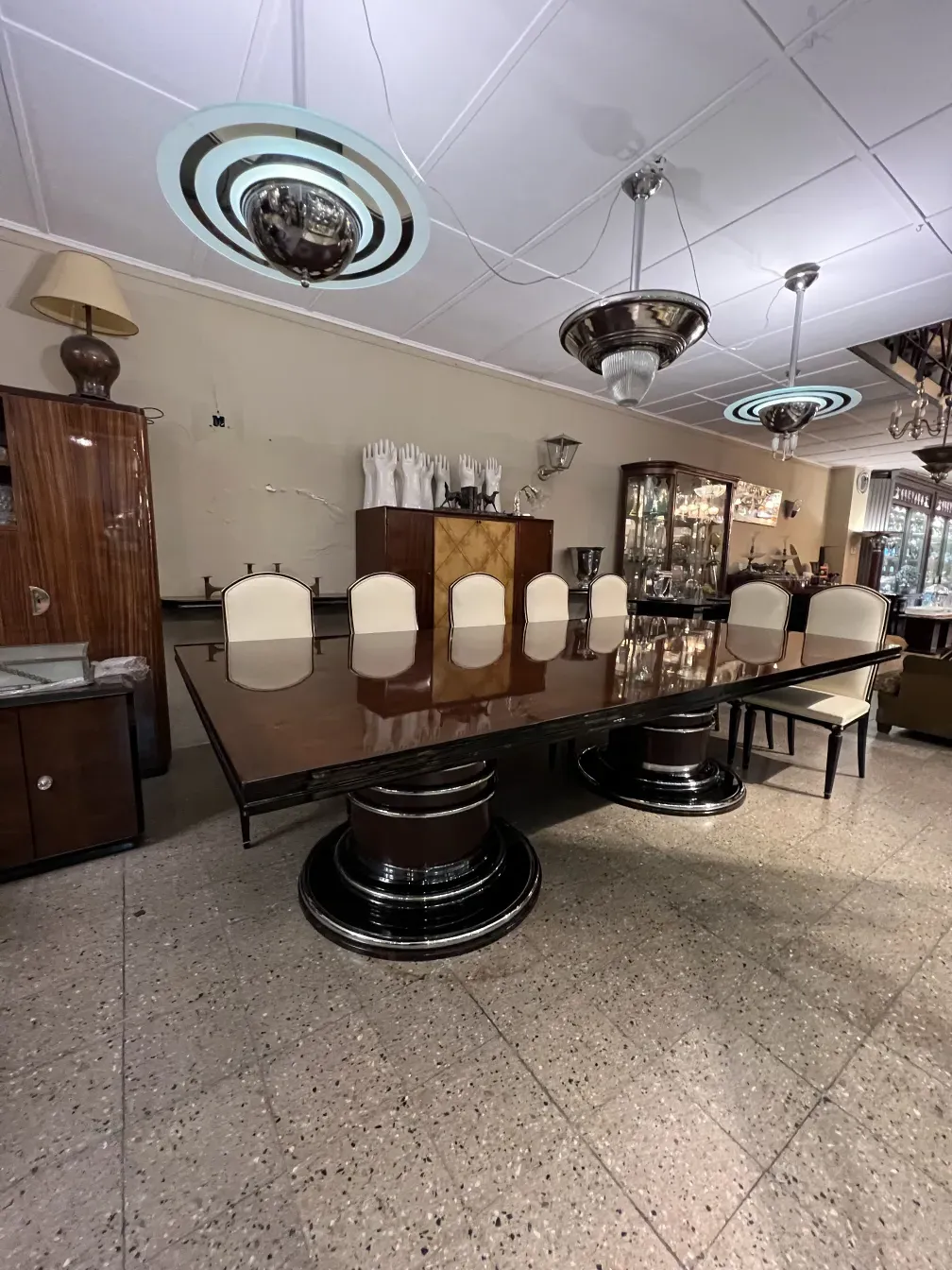 mesa de jantar antiga para 14 pessoas com cadeiras brancas em um ambiente elegante