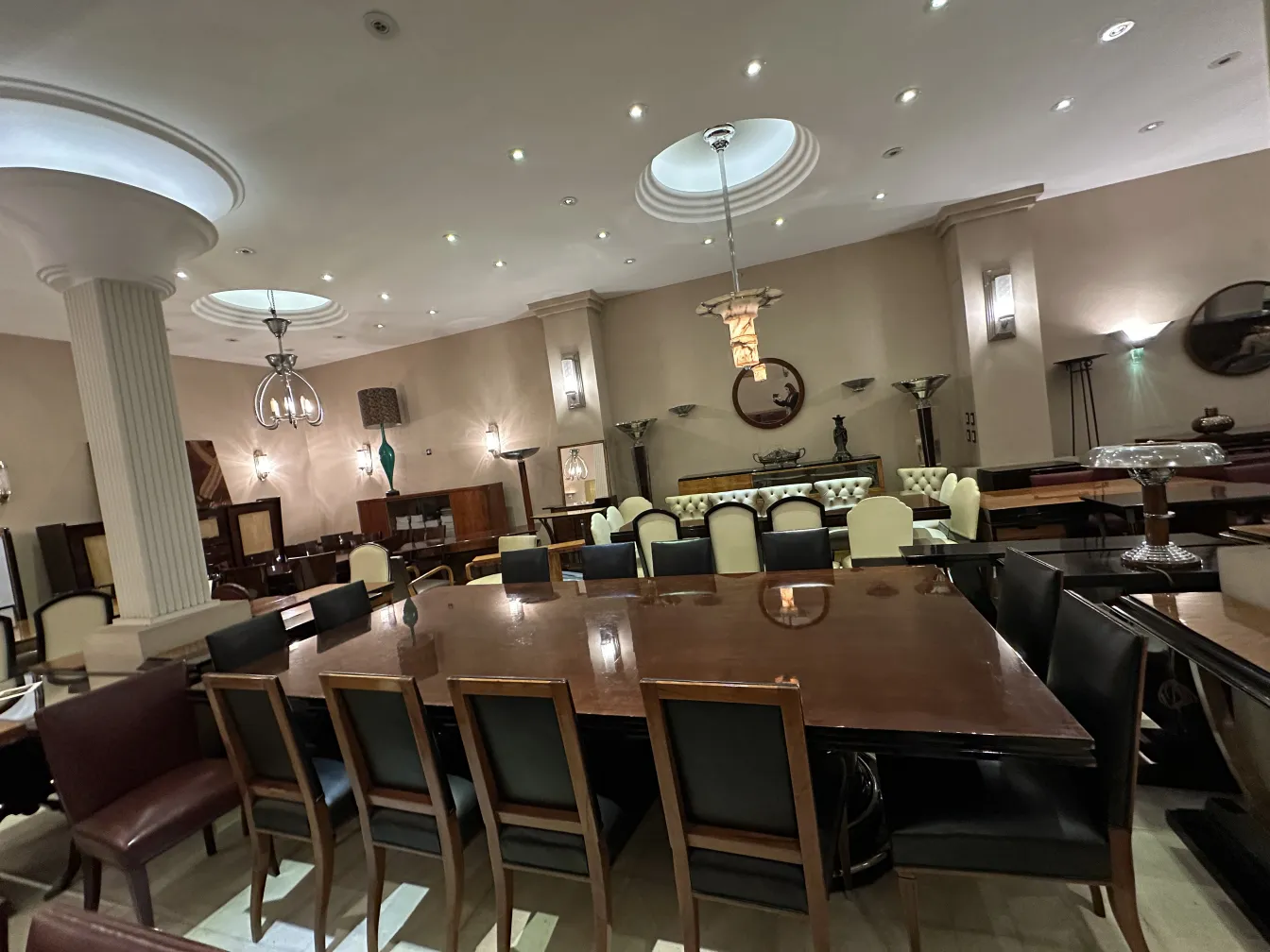 Tavolo da pranzo antico per 14 persone con sedie nere in un ambiente elegante.