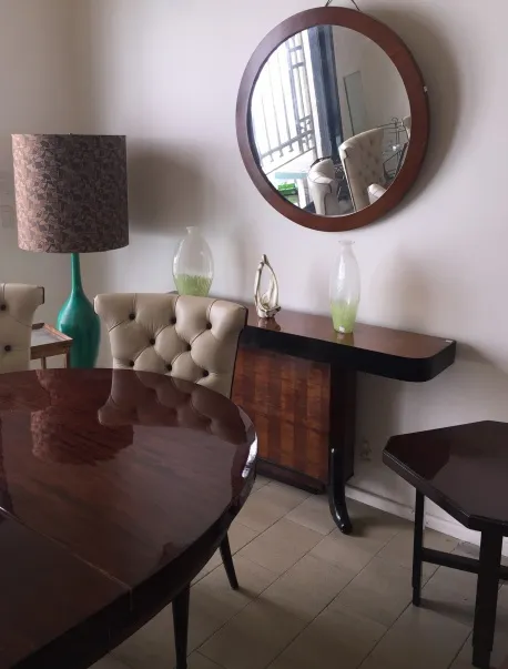 Mesa de comedor antigua en ambiente elegante con lámpara.