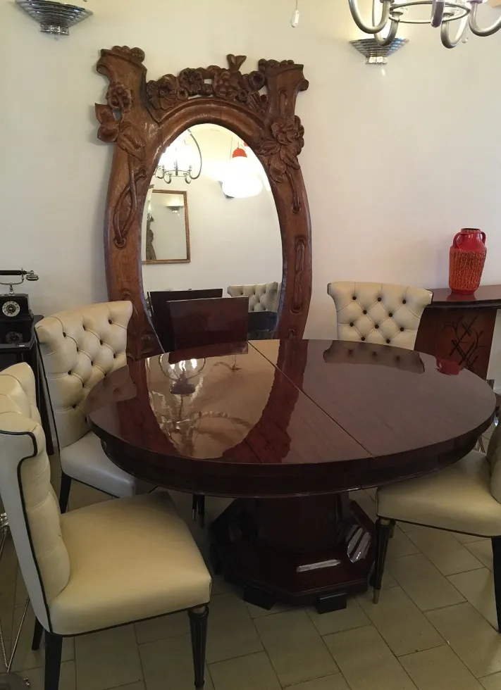 Mesa de comedor antigua para 4-8 personas con sillas y un gran espejo.