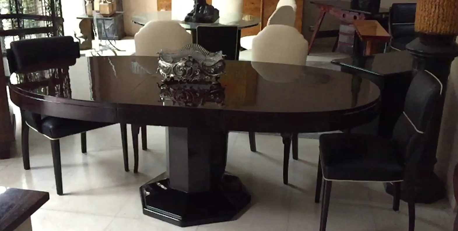 Mesa de jantar antiga para 6-8 pessoas com design clássico, disposta em um ambiente acolhedor.