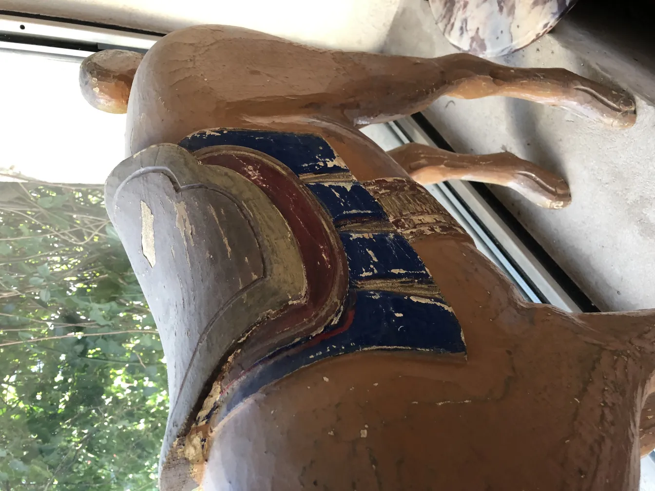 figura antigua de llama con detalles coloridos en la espalda