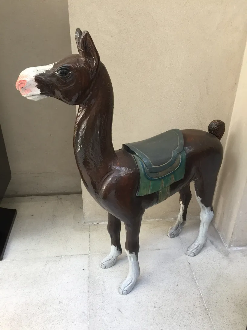 antique decorative llama figure with saddle.