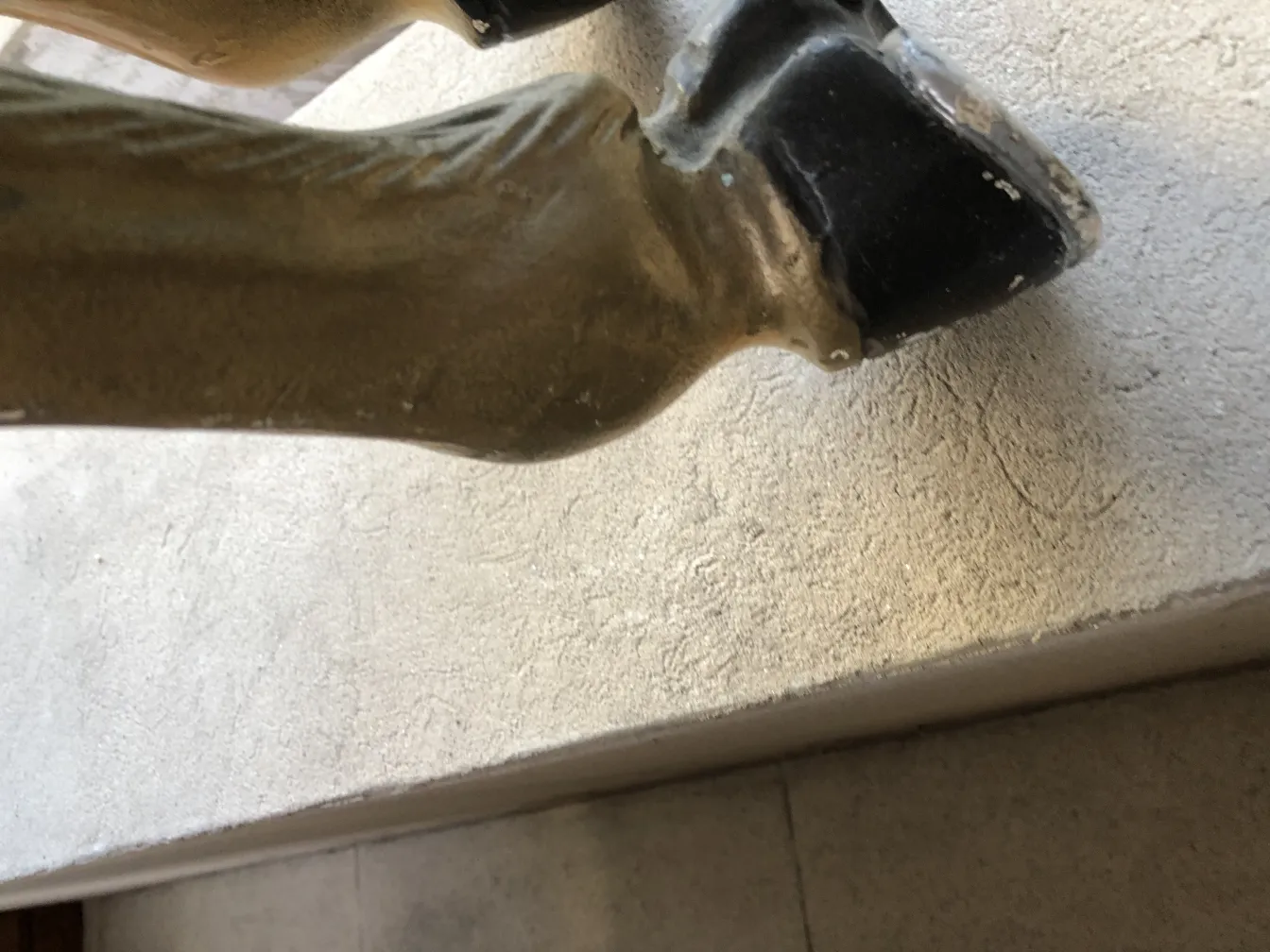 Estatuilla de unicornio antiguo con detalles visibles en su base.