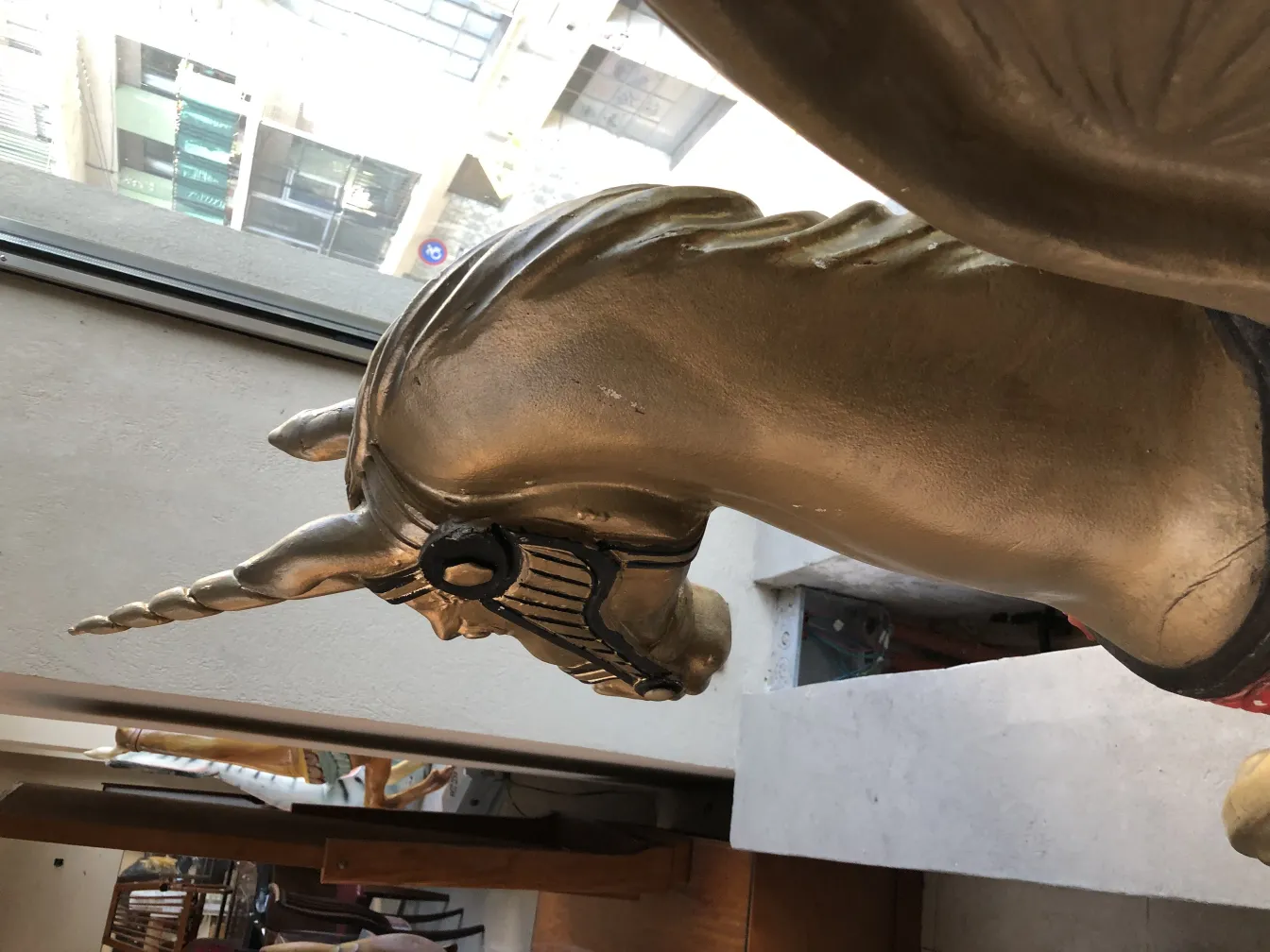 Scultura antica di un unicorno dorato con dettagli