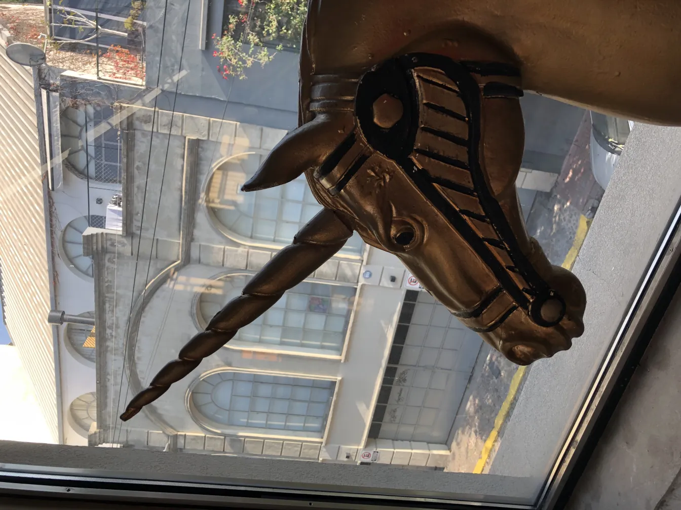 Cabeza de un unicornio dorado mirando por una ventana