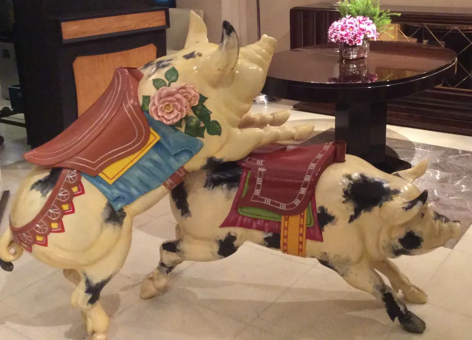 Antique pig with striking decoration and flowers, elegant setting.