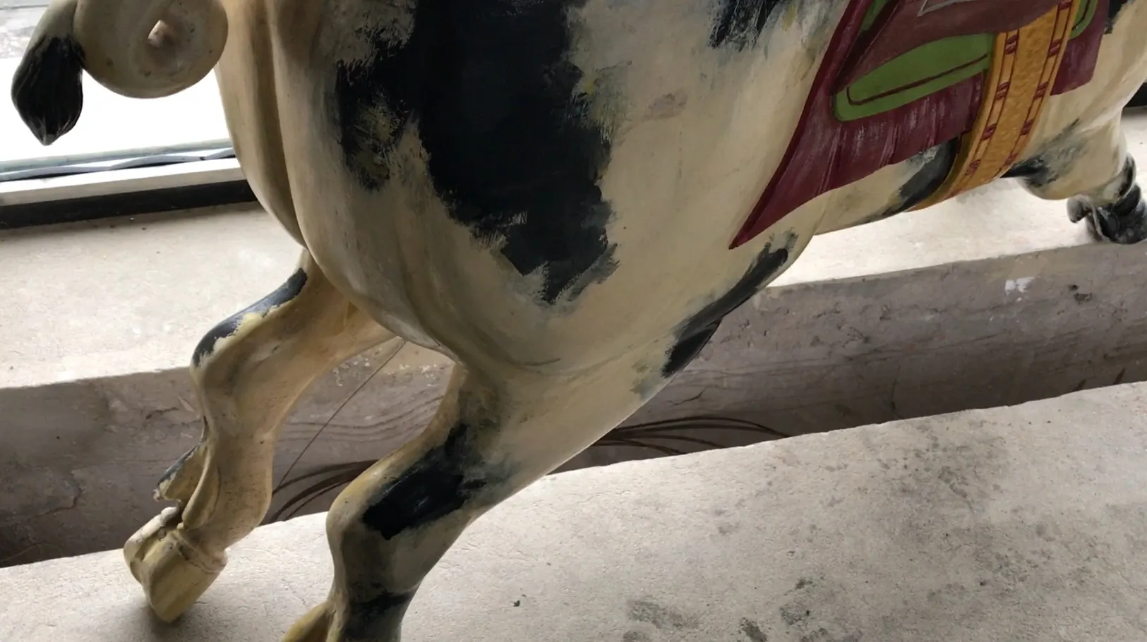 Antigo porco decorativo com cores desgastadas em um fundo simples