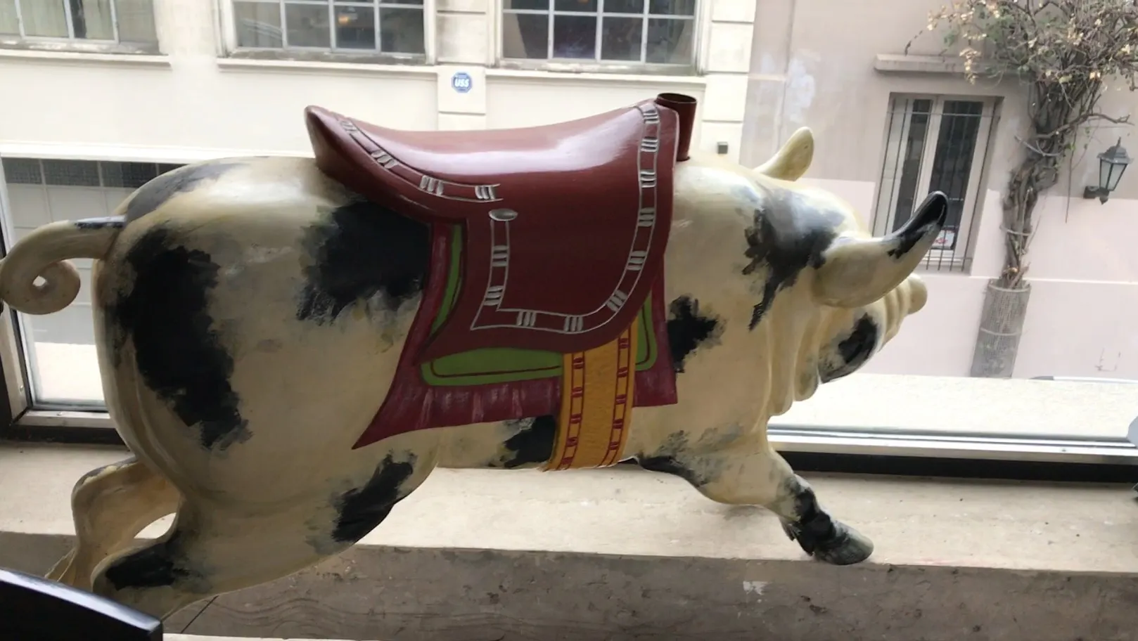 Antique pig figurine featuring a red saddle with black and cream colors.
