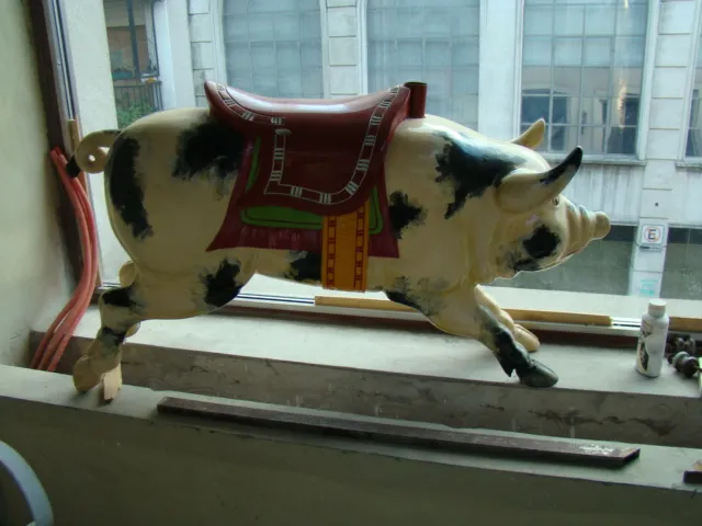 Antique decorative pig with saddle in window, colorful details