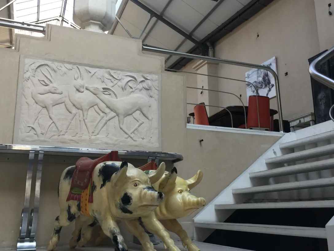 Antike Schweine-Skulptur in einer dekorativen Umgebung.