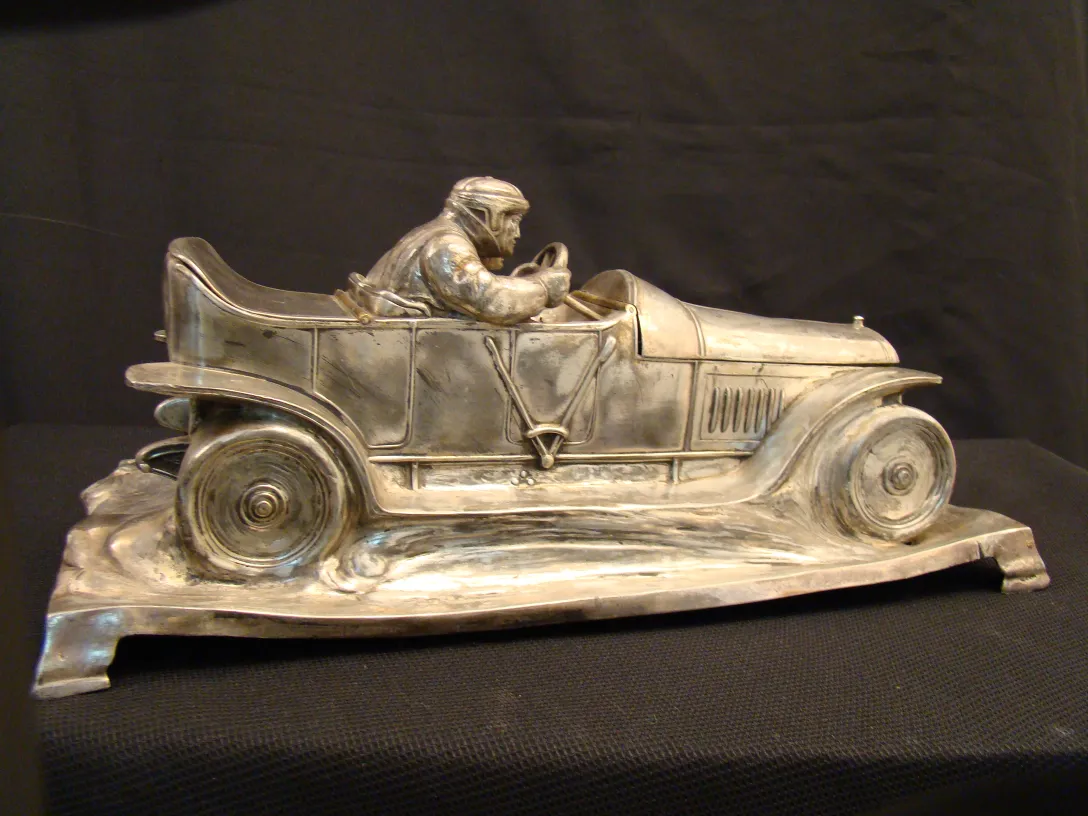 tintero antiguo con figura de conductor sobre un coche