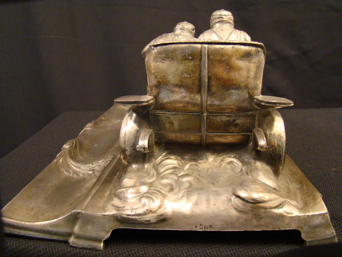 Ancien encrier WMF avec décoration détaillée et fond sombre.