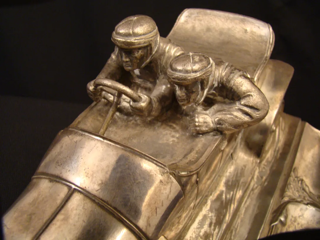 encrier ancien avec des figurines de coureurs de voitures
