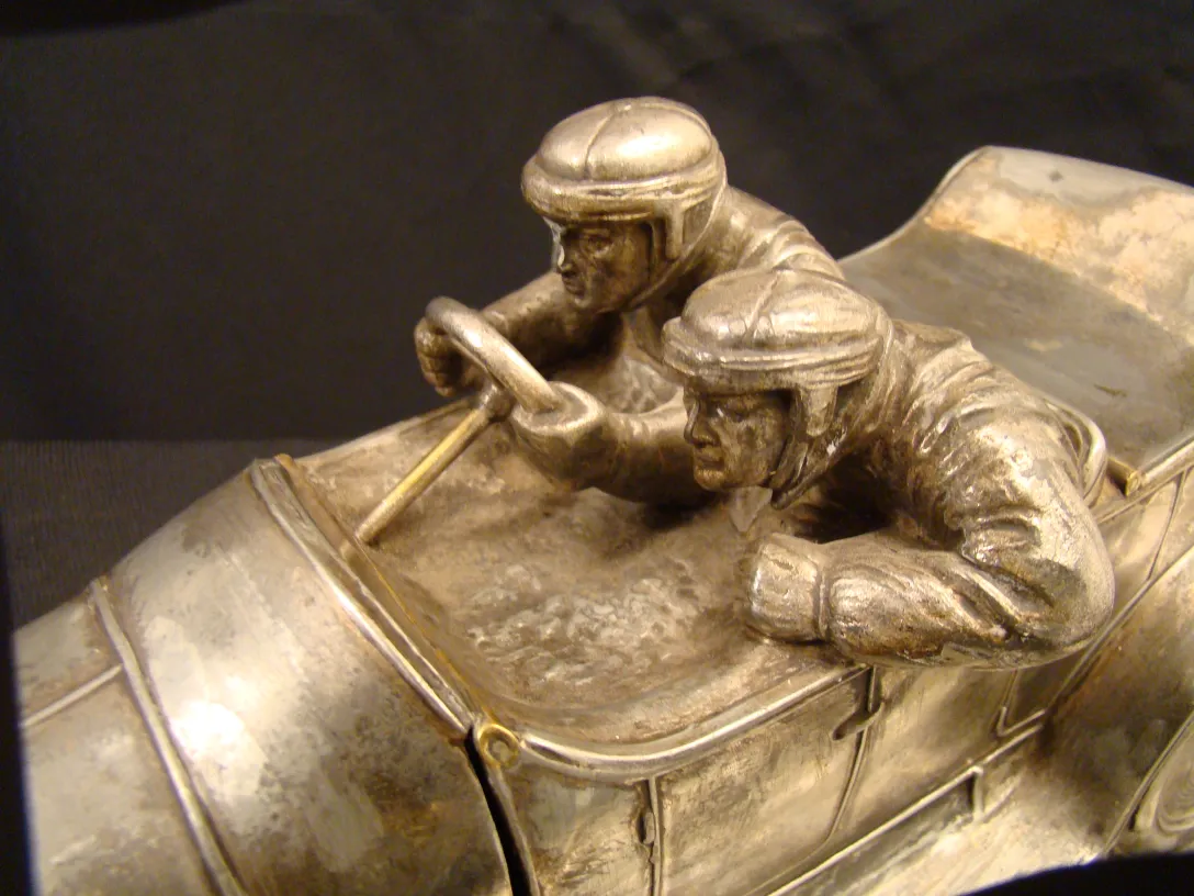 Antique inkwell featuring details of racing car drivers.