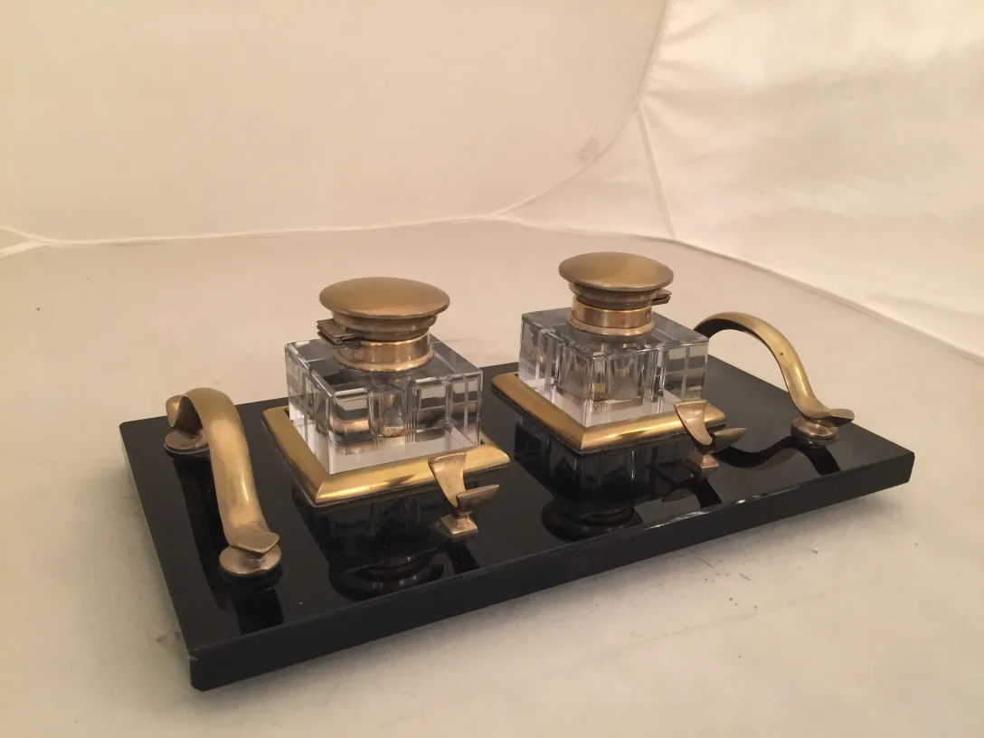 Antique inkwell with two heads on a black base.