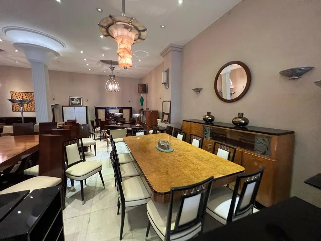 Paire d'appliques anciennes dans un environnement décoratif avec table et chaises.