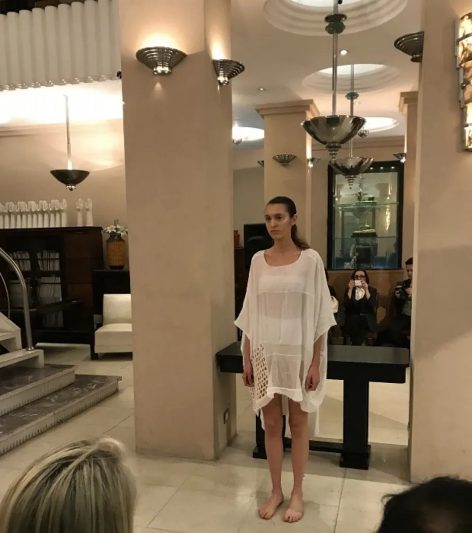 Paire d'appliques anciennes illuminant une scène de mode avec modèle et public.