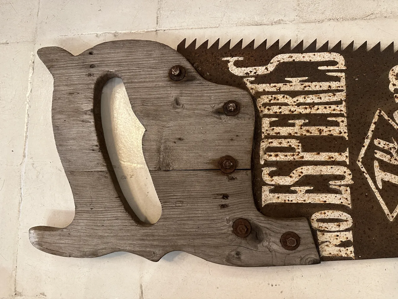 Antique hand saw with advertising details and craft setting