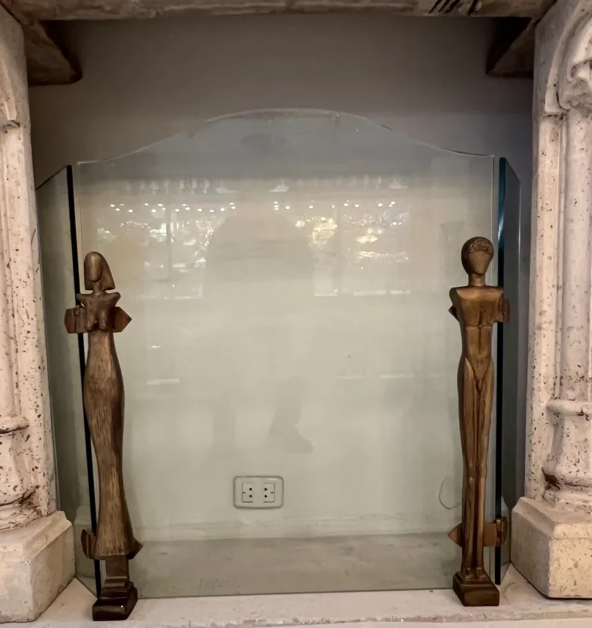 Fireplace front with Alberto Giacometti figures and glass