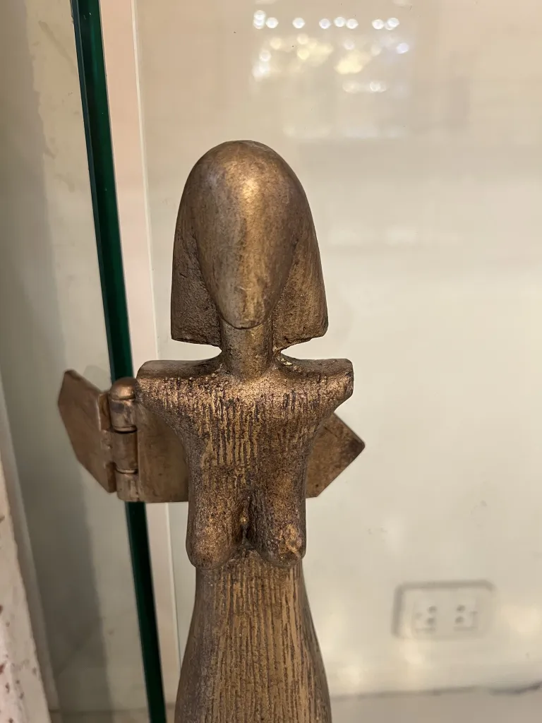 Representação estilizada de um frente de lareira antigo em bronze com formas distintas, ambiente aconchegante.