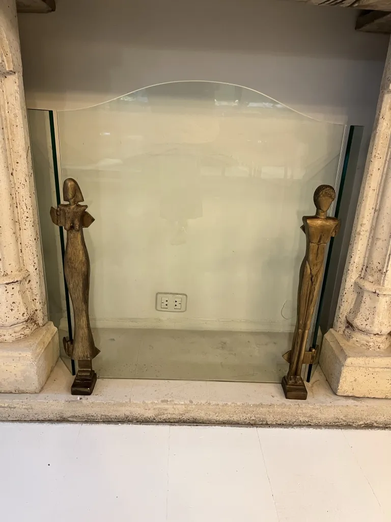 frente de chimenea con esculturas de Alberto Giacometti en un ambiente antiguo