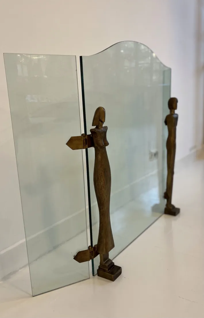 Frente de chimenea antiguo con figuras estilizadas de Alberto Giacometti, ambiente acogedor.