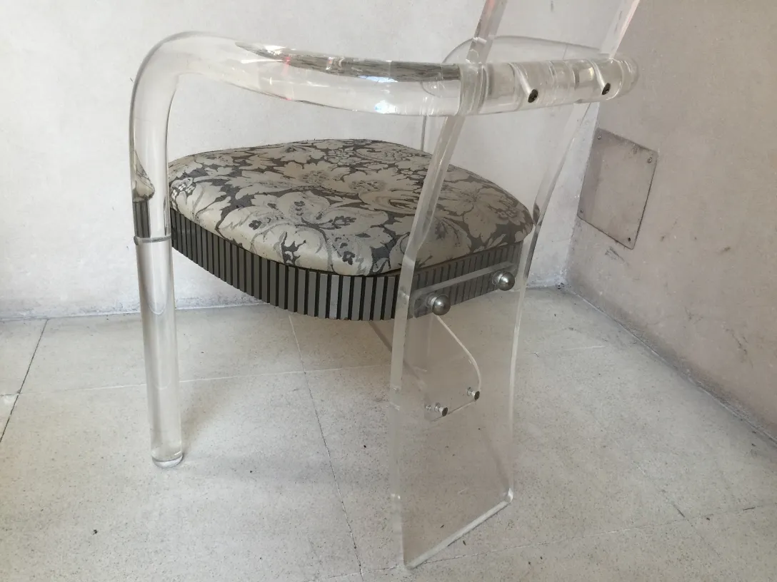 vista de cadeira antiga com almofada decorativa e fundo neutro