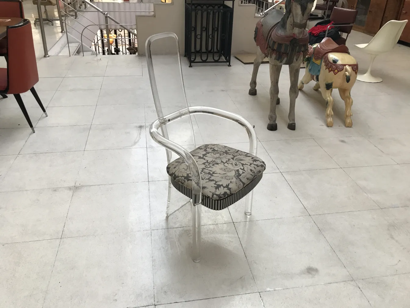 चार प्राचीन कुर्सियाँ और दो आर्मचेयर तटस्थ वातावरण में सजावटी लकड़ी के घोड़ों के साथ।