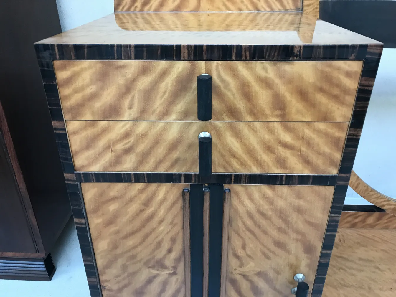 Un tocador antiguo de estilo Art Deco con acabados elaborados y dos cajones.