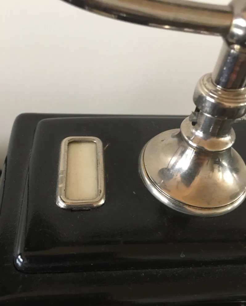 teléfono antiguo con base negra y detalles brillantes