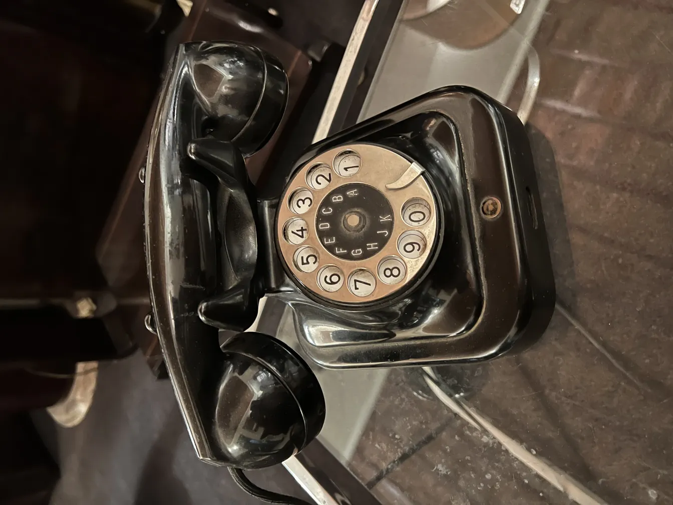 Teléfono antiguo mecánico con disco giratorio en un ambiente elegante.